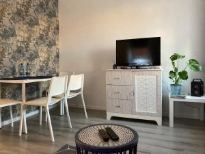 a living room with a television and a table and chairs at Habibi Plac Ratuszowy in Jelenia Góra