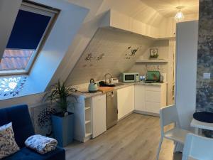 a small kitchen with white cabinets and a table at Habibi Plac Ratuszowy in Jelenia Góra