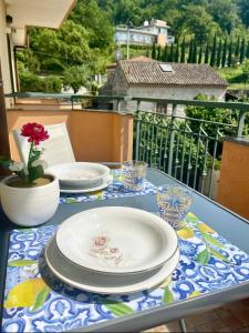 ein Tisch mit Tellern und Gläsern auf einem Balkon in der Unterkunft Luxury Apartment Vanacore in Castelnuovo Cilento