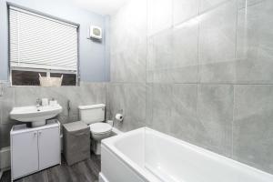a bathroom with a toilet and a sink and a tub at Exceptional 5 stars flat in lovely location in London