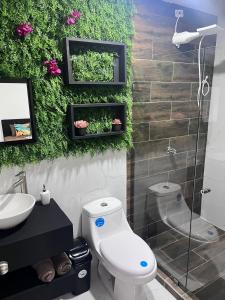 a bathroom with a toilet and a sink at Tortuguero Villas in Tortuguero