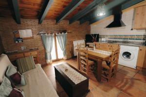 a kitchen with a table and a washing machine at Apartamentos Rurales Casa del Tio Juan in Olocau del Rey +53 photos