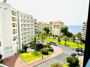 uma vista para uma rua da cidade com edifícios e o oceano em Smarts Apartment da Ajuda em Funchal