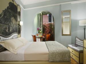 a bedroom with a white bed and a chair at Grand Hotel Savoia in Genoa