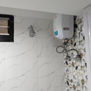 um quarto com um secador de cabelo numa parede branca em Deep Home stay em Agartala