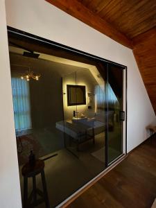 ein großes Glasfenster in einem Zimmer mit einem Tisch in der Unterkunft Molla Guest House in Theth