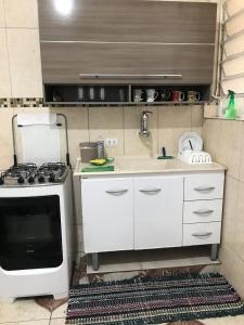 a small kitchen with a sink and a stove at No Bom Retiro ap amplo com Wi-Fi in São Paulo