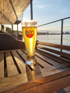 un bicchiere di birra seduto sopra un tavolo di B&B Botel Charlie a Belgrado
