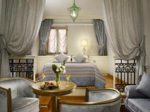 a bedroom with a bed and a table and chairs at Grand Hotel Savoia in Genoa