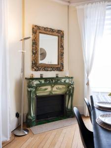 a living room with a fireplace and a mirror at Luxe Poincare in Nancy