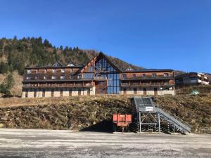 ein großes Gebäude auf einem Hügel in der Unterkunft Le fleuri ensoleillé de Guzet in Ustou