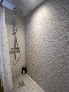 een douche in een badkamer met een betegelde muur bij Apartment Kvartsi in Tartu