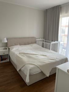 a white bedroom with a bed and a window at Apartment Kvartsi in Tartu