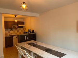 ein Esszimmer mit Tisch und eine Küche in der Unterkunft Le fleuri ensoleillé de Guzet in Ustou