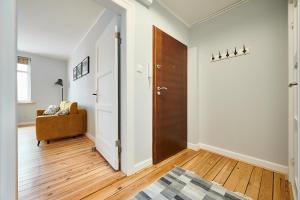 een hal met een deur en een stoel in een kamer bij Apartament Drewno i Biel 54 M2 in Olsztyn