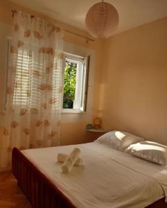 Schlafzimmer mit einem Bett mit weißer Bettwäsche und einem Fenster in der Unterkunft Apartman Marine in Prvić Luka