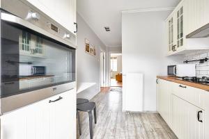 een keuken met witte kasten en een aanrecht bij Apartament Drewno i Biel 54 M2 in Olsztyn