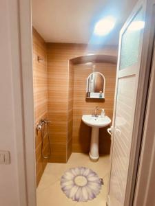 La petite salle de bains est pourvue d'un lavabo et d'un miroir. dans l'établissement Sofia's Rooms, à Himarë
