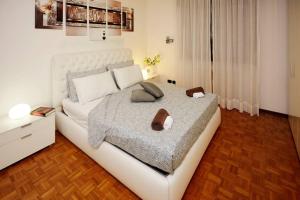 una camera da letto con un grande letto bianco con scarpe di Elegance and comfort a due passi da SACILE CENTRO a Sacile