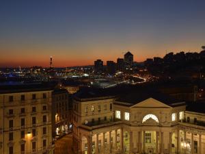 a view of a building with a city at night at Grand Hotel Savoia in Genoa