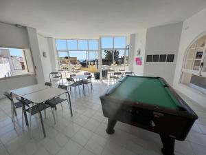 a pool table in a room with tables and chairs at Apartaments Monjardí in Lloret de Mar