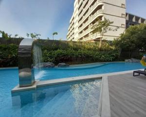 a swimming pool with a fountain in front of a building at Marvest Huahin-Discover Comfort and Convenience in Hua Hin
