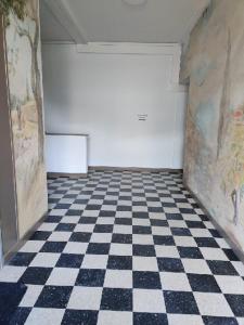 Cette chambre est dotée d'un sol en damier et d'un mur blanc. dans l'établissement Appartement Lisa, à Lézignan-Corbières