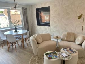 a living room with a table and a couch and chairs at The Roosevelt Apartments in Middelburg