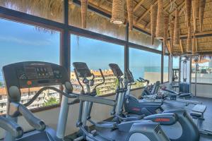 una fila de bicicletas estáticas en un gimnasio con una gran ventana en Nayri Life & Spa 408, en Puerto Vallarta