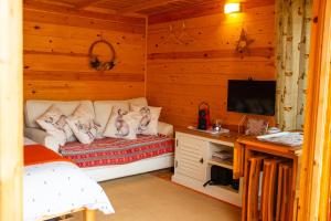 a bedroom with a bed and a desk with a television at Moors Wood Relaxing ,Tranquil retreat with Hot Tub in Chippenham