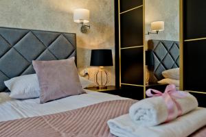 een slaapkamer met een bed met handdoeken en een spiegel bij BlueApart Apartamenty Hotelowe Nexo II in Puck
