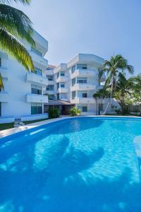 a large swimming pool in front of a building at Suites Turquesa in Cozumel