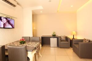 a dining room with a table and chairs and a tv at Hotel Luciya Palace in Trichūr