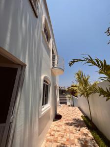 une maison blanche avec une passerelle à côté d'un bâtiment dans l'établissement Residencia en el centro de Puerto Escondido, à Puerto Escondido