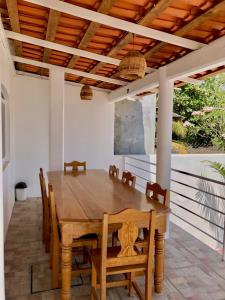 Une table à manger en bois et des chaises sont disponibles sur la terrasse. dans l'établissement Residencia en el centro de Puerto Escondido, à Puerto Escondido
