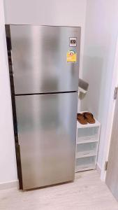 a stainless steel refrigerator in the corner of a kitchen at Marvest Huahin-Discover Comfort and Convenience in Hua Hin