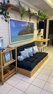 un sofá en una habitación con una gran imagen del océano en Hospedagem Galés Maragogi, en Maragogi