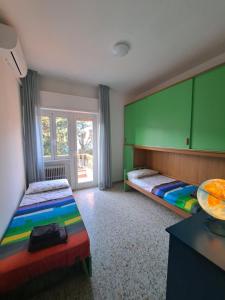 a bedroom with two beds and a green wall at Il Balcone sull'Elba in Piombino