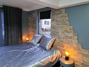 una camera con un grande letto e un muro di pietra di Gîte 'Toi et moi ' a Graux