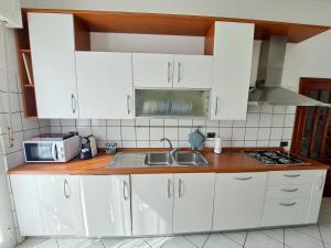 a kitchen with white cabinets and a sink at Il Balcone sull'Elba in Piombino