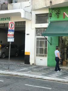 kobieta idąca ulicą przed budynkiem w obiekcie No Bom Retiro ap amplo com Wi-Fi w São Paulo