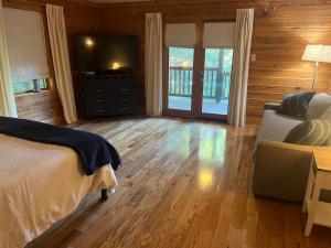 Schlafzimmer mit einem Bett und einem Flachbild-TV in der Unterkunft Lakefront-Private-Huge Log Cabin 