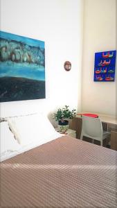 een slaapkamer met een bed en een schilderij aan de muur bij Casa Migliore in Palermo