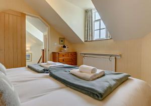 a bedroom with two beds with towels on them at Skyes House in Southwold
