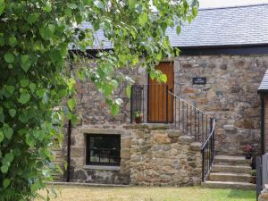 a stone house with a staircase and a door at The Hayloft in Helston