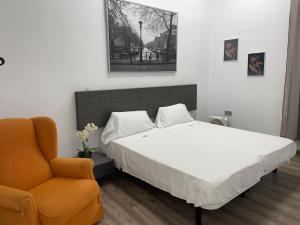 een slaapkamer met een bed en een stoel bij The Cathedral Hostel in Murcia