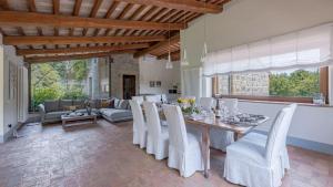 a dining room with a table and white chairs at Villa Collombroso in Porano