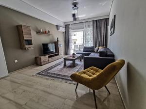 a living room with a couch and a chair at Silver Central Apartment in Volos