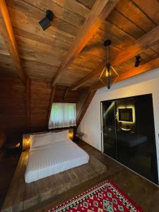 Bett in einem Zimmer mit Holzdecke in der Unterkunft Molla Guest House in Theth