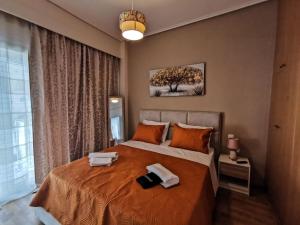 a bedroom with a bed with two towels on it at Silver Central Apartment in Volos